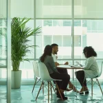 a serene and inviting consultation room, filled with soft natural light, where a diverse group of individuals engages in a thoughtful discussion, reflecting the intersection of psychology and immigration.